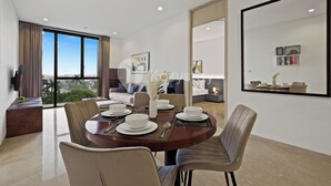 A modern dining area with a round table set for four, surrounded by chairs. - Oswin by Kozystay - Cilandak (Jakarta)