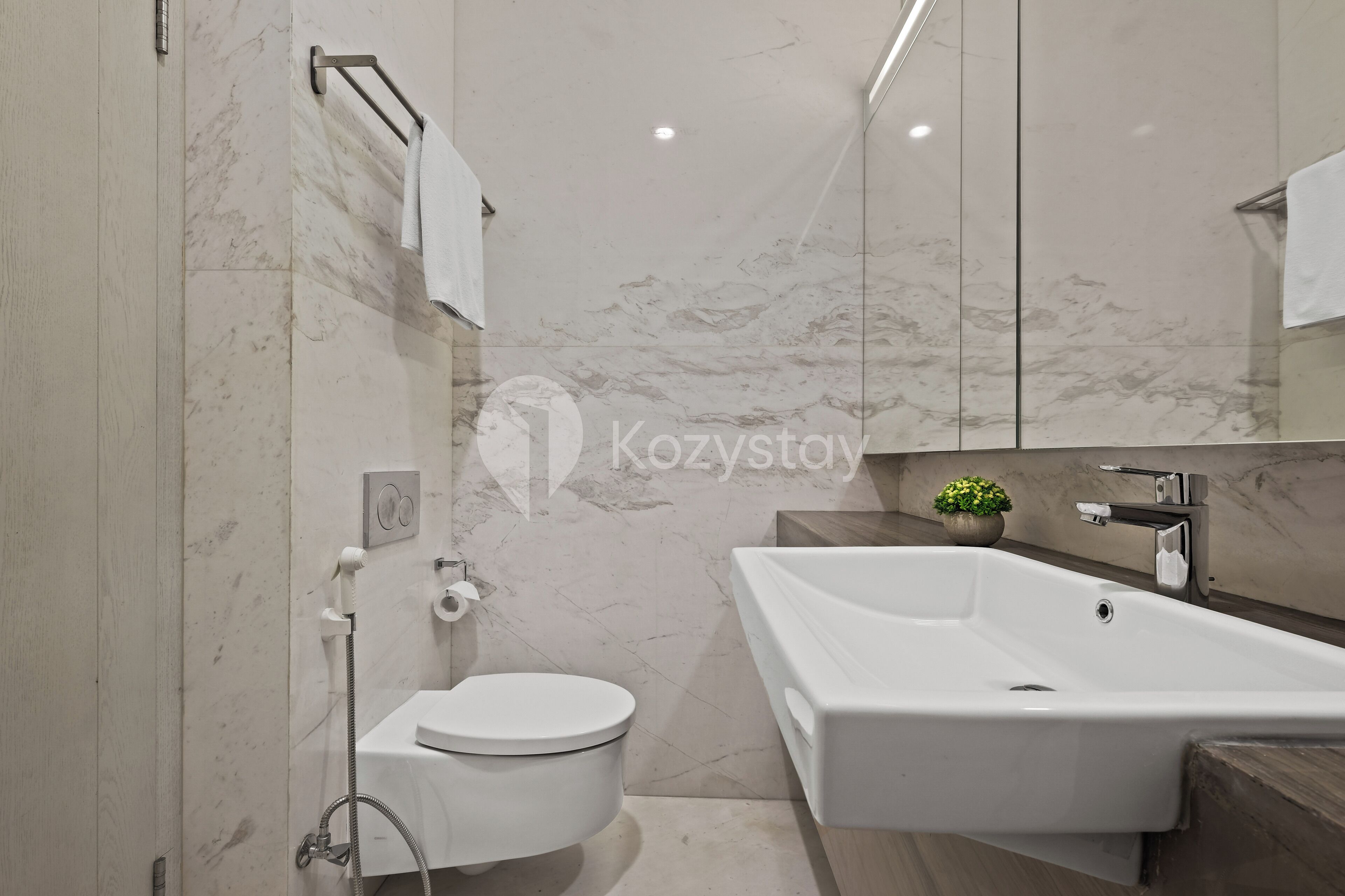 A modern bathroom with a toilet, sink, and shower.
