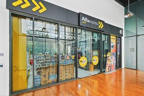 En butik med en stor glasfasad där olika produkter visas upp, och en skylt med texten ”Alfaexpress”.