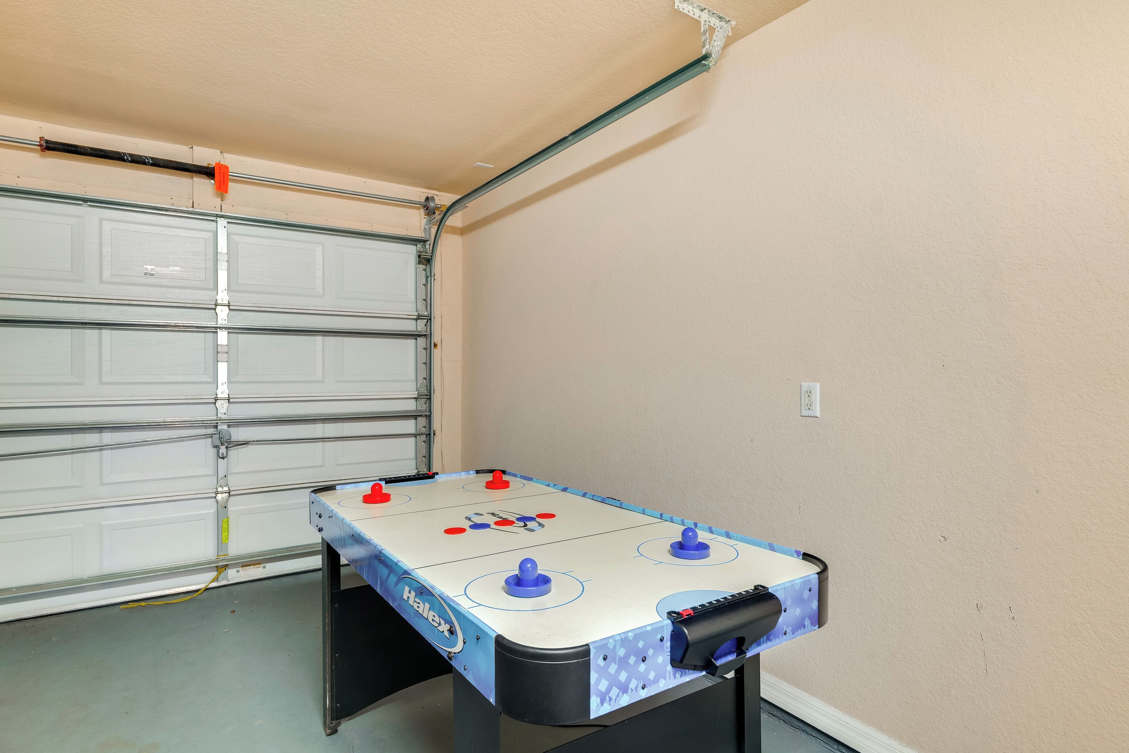 A foosball table in a garage with a garage door in the background.
