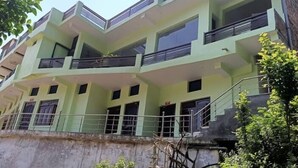 Un edificio a più piani con balconi, ampie finestre e facciata in cemento.