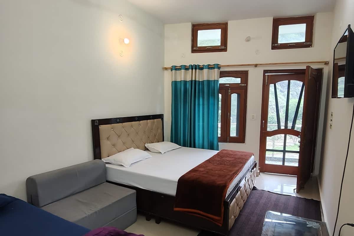 Une chambre à coucher comprenant un lit, un canapé, un bureau, un ventilateur de plafond et une fenêtre avec des rideaux.