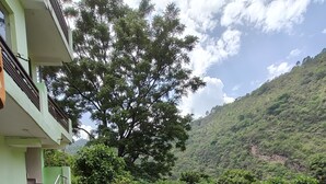 Un edificio con una scalinata che conduce a un balcone, immerso nel verde e su una collina.