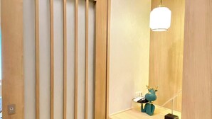 Een moderne badkamer met een houten wastafelmeubel, een spiegel en een decoratief object in turquoise.