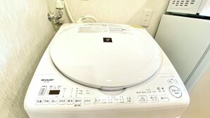 Een wit Sharp ES-TX8J toilet met een bedieningspaneel met diverse knoppen en een digitaal display.