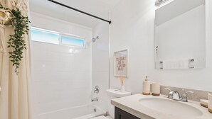A modern bathroom with a bathtub, toilet, and sink. - 3-bedroom family and pet friendly just 12 minutes from Joshua Tree National Park (Joshua Tree)