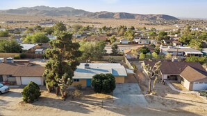 A residential area with houses, trees, and mountains in the background. - 3-bedroom family and pet friendly just 12 minutes from Joshua Tree National Park (Joshua Tree)