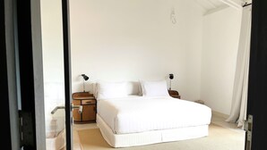 A bedroom with a bed, bedside tables, a lamp, and a woven mat on the floor. - Lovely 2BR Villa Close to The Beach (Seminyak)