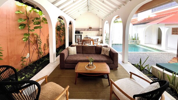 A spacious indoor area with a pool, a dining area, and a seating area with a sofa and chairs. - Lovely 2BR Villa Close to The Beach (Seminyak)