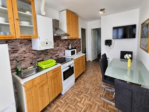 A kitchen with wooden cabinets, a microwave, a stove, and a sink. - 2BR Apt Next to Vienna Vibrant Center (Vienna)