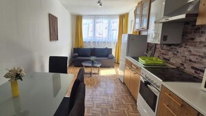 A compact living space with a kitchenette, a dining area, and a sofa. - 2BR Apt Next to Vienna Vibrant Center (Vienna)
