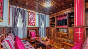 A cozy living room with striped sofas, a wooden coffee table, and a bookshelf. - Peaceful 4-Bedroom Villa with Private Pool (Siem Reap)