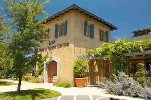A building labeled 'Lodi Wine & Visitor Center' with a traditional architectural style, featuring a pitched roof and arched entrance. - Charming 3-Bedroom Farmhouse Retreat w/ Open Deck! (San Joaquin County)