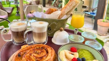 A breakfast tray with pastries, coffee, juice, and fresh fruit.