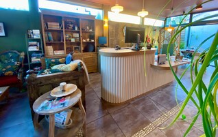 Ein gemütliches Interieur mit einer Rezeption, einer Bücherwand und einer komfortablen Sitzecke.