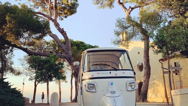 A white three-wheeled vehicle parked on a gravel path surrounded by trees and buildings. - Hôtel La Jabotte (Antibes)