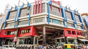 Un edificio de varios pisos con diversos comercios en la planta baja, incluyendo un hotel y un bar.