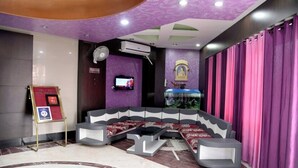 A hotel lobby with a seating area, a reception desk, and a television screen. - Hotel Heeralal Bikaner (Bikaner)