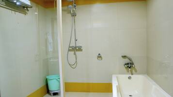 Une salle de bain avec douche, toilettes et baignoire.