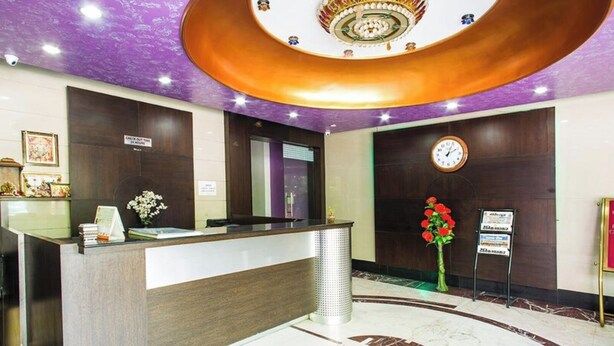 A hotel reception area with a modern design, featuring a reception desk, a clock, and a signboard. - Hotel Heeralal Bikaner (Bikaner)