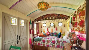 Een knus ingerichte kamer met een bed, bureau, stoel en raam.