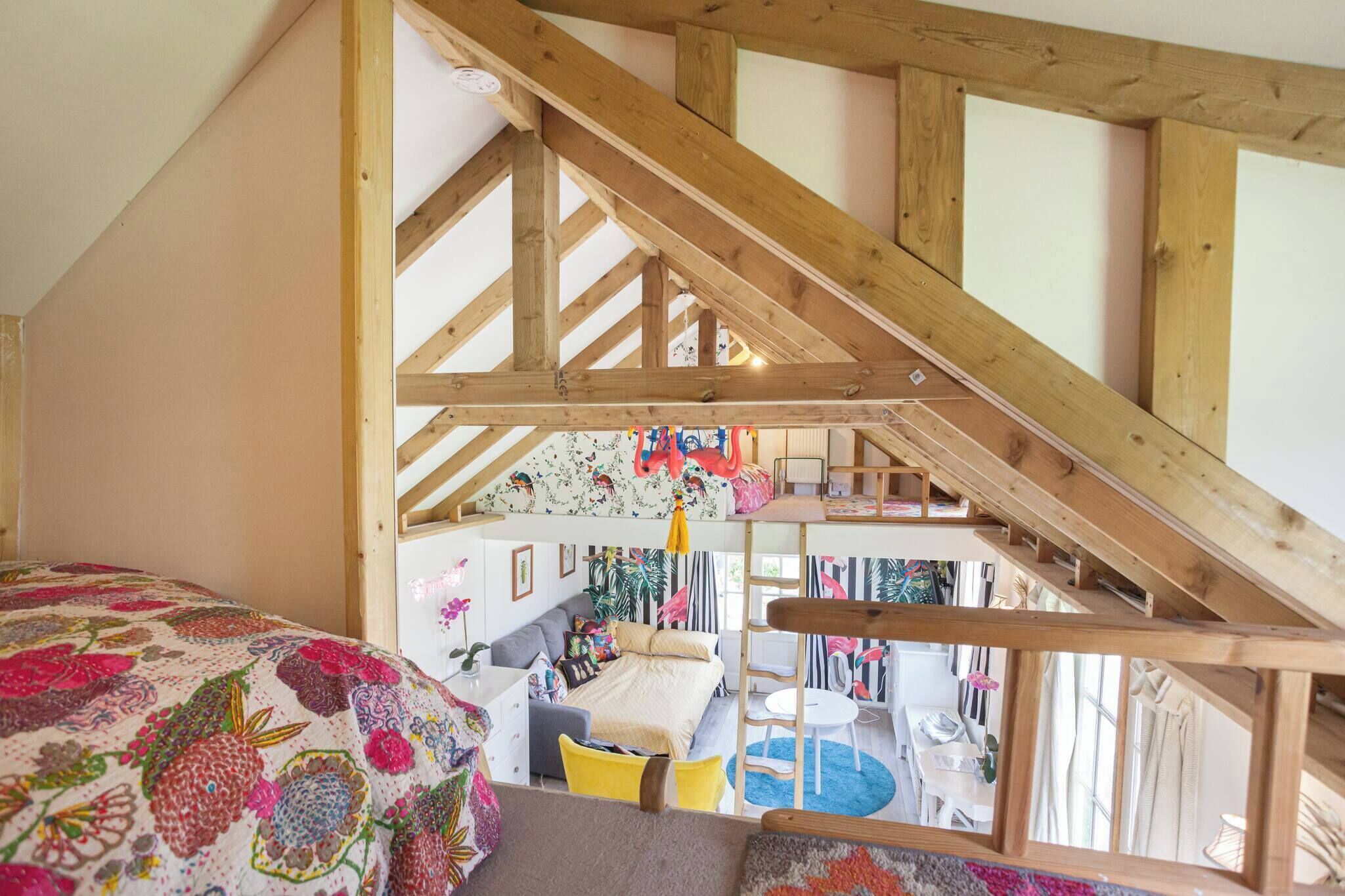 Ein Schlafzimmer im Loft-Stil mit schrägem Dach, Etagenbett und Schreibtisch.