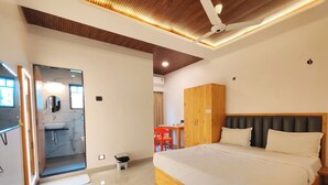 A modern hotel room with a large bed, wooden wardrobe, and a bathroom with a mirror and sink. - Hotel Satkar Inn (Khalapur)