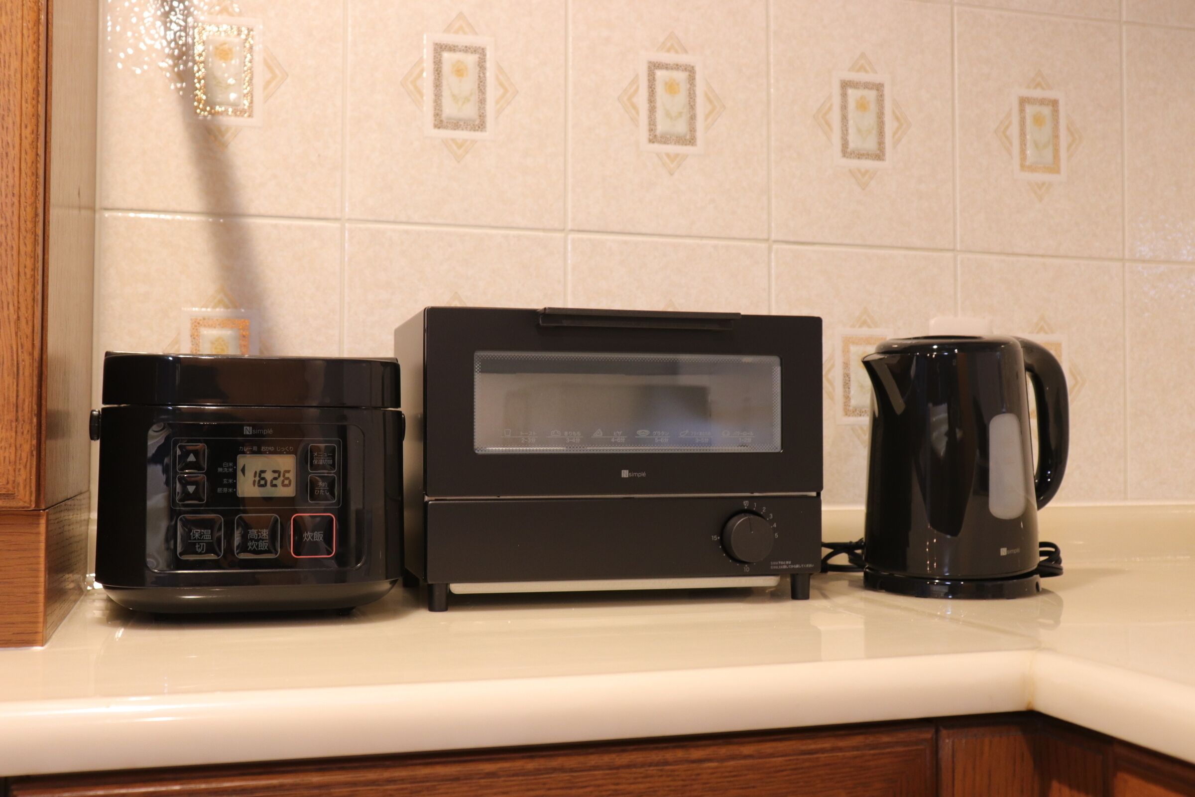 A kitchen with a coffee maker, a rice cooker, and a toaster on the counter.