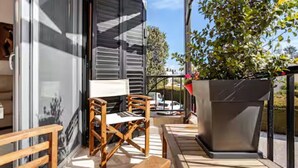 A patio area with a wooden bench, a table, and a potted plant. - Gorgeous Apartment in Paradise Complex (Paphos)