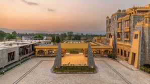 A courtyard with a central open space, surrounded by buildings with traditional architecture. - Raj Leela Heritage Resort by Estherea (Ghanerao)