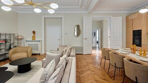 Una sala de estar moderna con un sofá, una mesa de centro y un comedor con sillas y una mesa dispuesta para una comida.