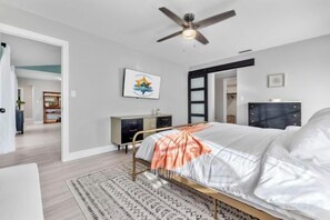 A bedroom with a bed, a ceiling fan, a dresser, and a rug. - Villa Tarpon Terrace (Cape Coral)