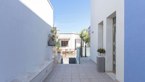 A narrow, tiled corridor with a view of a building in the distance. - Residence Borgo & Mare (Melendugno)