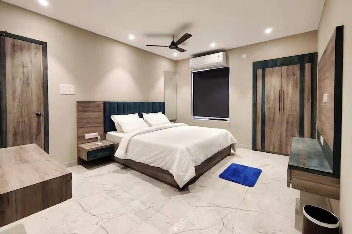 Een slaapkamer met een bed, nachtkastje en plafondventilator.