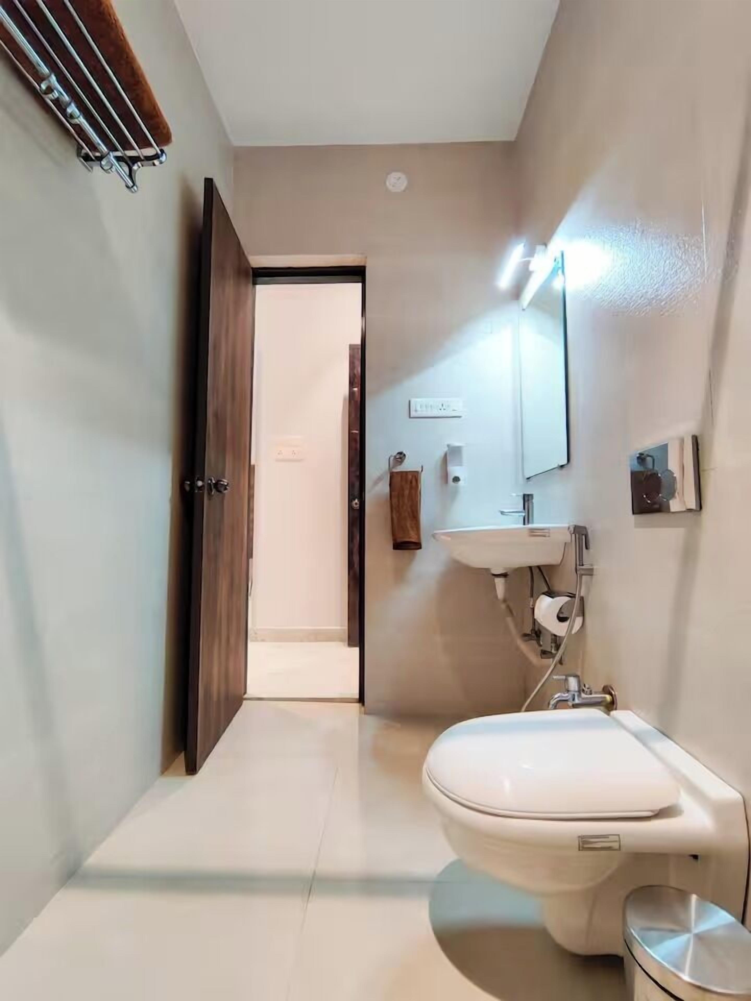 Ein modernes Badezimmer mit Toilette, Waschbecken und Spiegel.