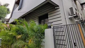 A modern building with a unique architectural design, featuring a prominent sloped roof and a gated entrance. - Stay by Insata Hospitality - Kolkata (Bidhannagar)