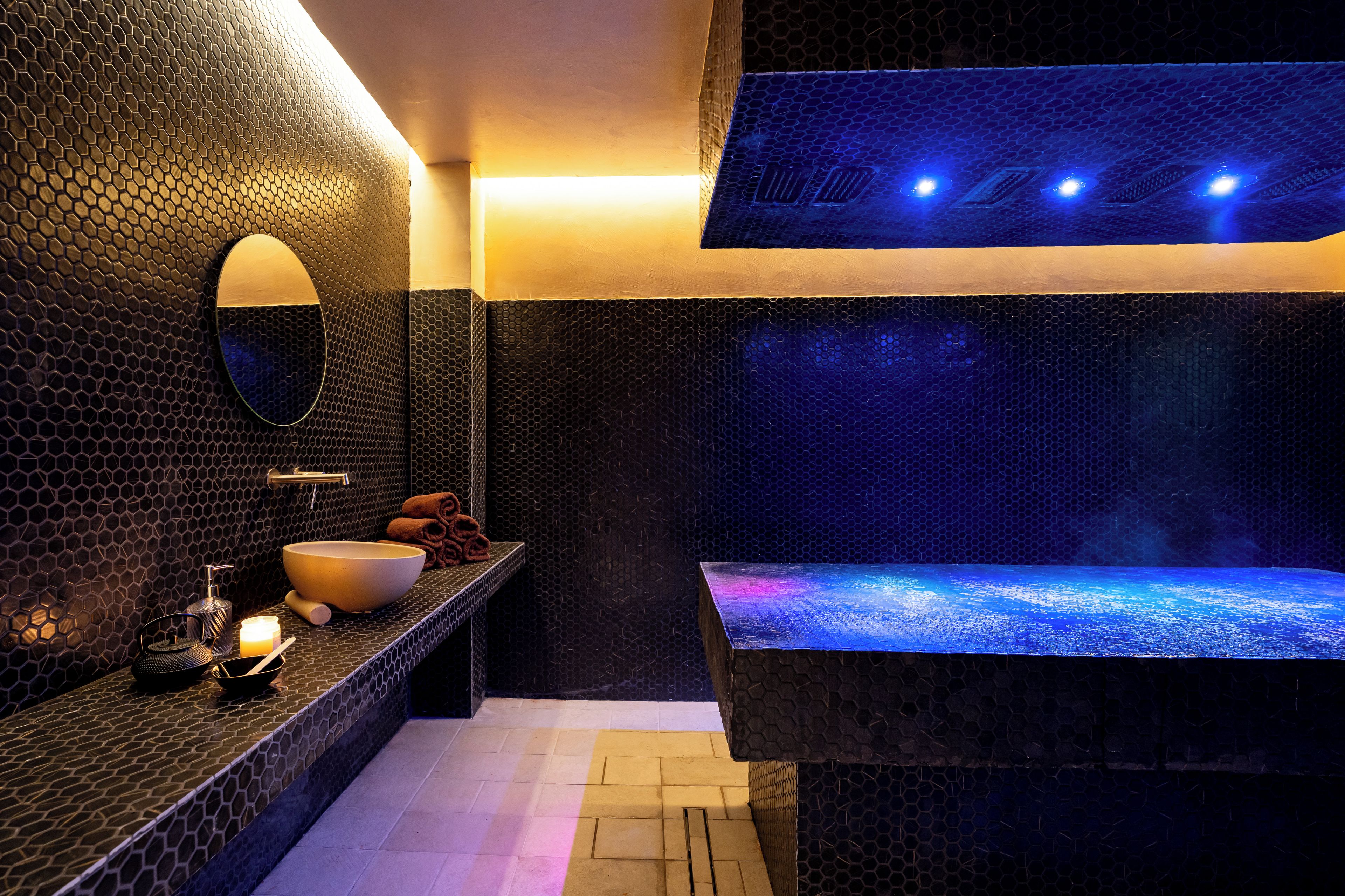 Une salle de bain moderne avec un grand miroir, un lavabo et un plancher chauffant.