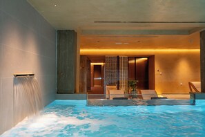 A modern indoor pool area with a water feature, seating, and a view into a hallway. - ARATO by E•GEO, Adults Only (Kos)