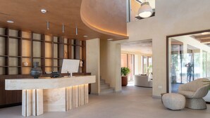 A reception desk with a modern design, a staircase leading to an upper level, and a seating area with a plant. - ARATO by E•GEO, Adults Only (Kos)