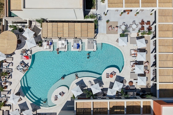 Una piscina al aire libre de temporada, sombrillas