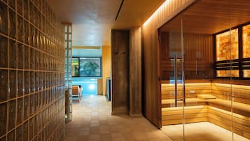 Un pasillo con una pared de vidrio a un lado y una pared de madera al otro, que conduce a un área de descanso con vistas al exterior.
