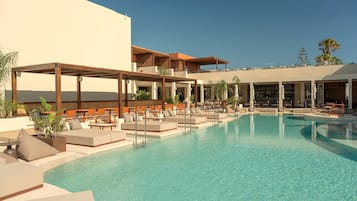 Una piscina al aire libre de temporada, sombrillas
