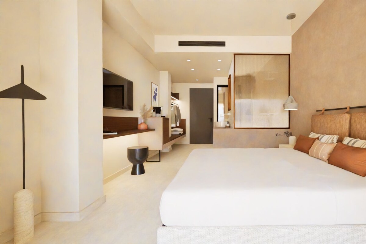 A modern hotel room with a large bed, a flat-screen TV, a bedside table, and a large window.