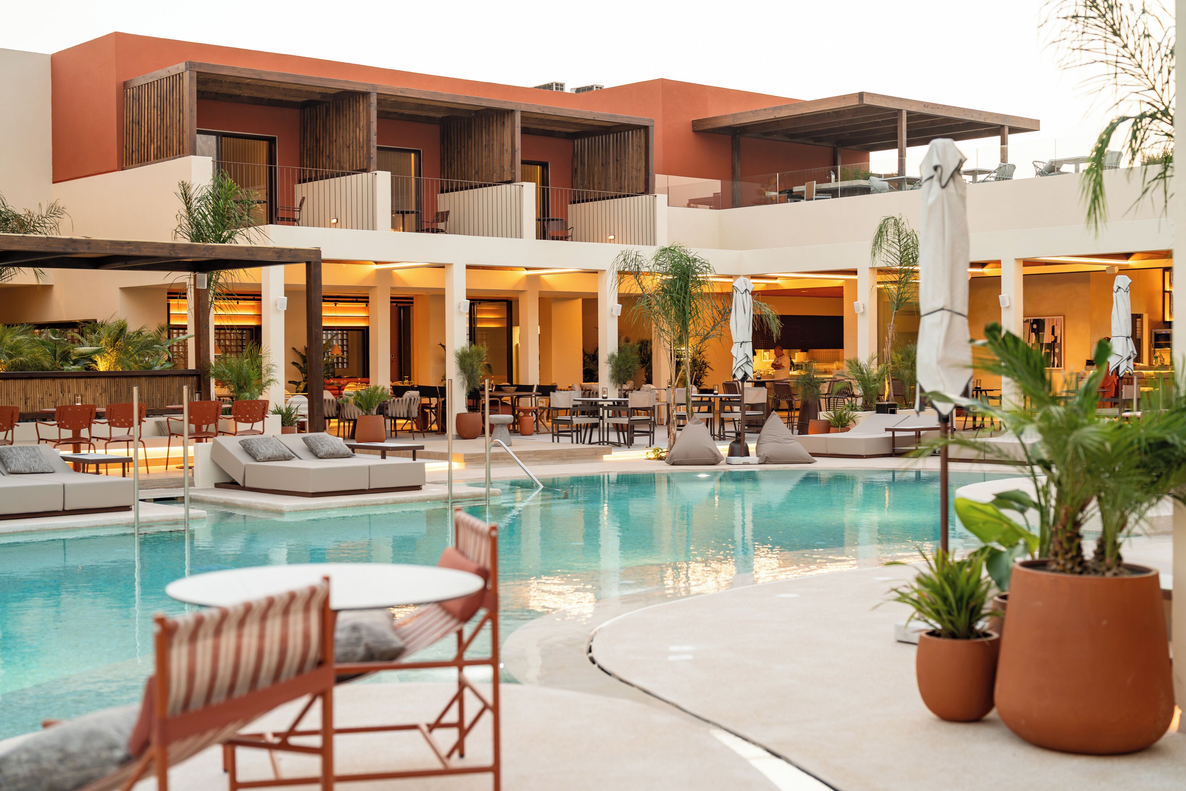 Un hotel con piscina, zona de estar al aire libre y restaurante.