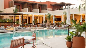 Un hotel con piscina, zona de estar al aire libre y restaurante.