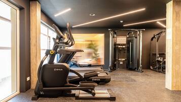 A gym with treadmills, a stationary bike, and weightlifting equipment.