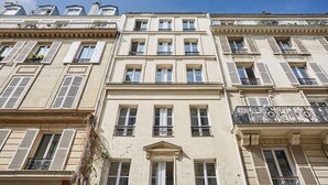 A multi-story building with a classical architectural style, featuring symmetrical windows and balconies with wrought iron railings. - New apartment Center of Paris/Le Marais (Paris)
