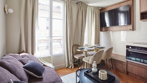 A modern living room with a sofa, dining area, and kitchen. - New apartment Center of Paris/Le Marais (Paris)