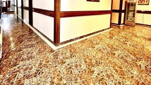 A hotel lobby with a marble floor, a reception desk, and a framed picture on the wall. - Hotel Woodcrest (Zirakpur)