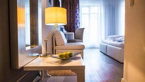 A hotel room with a desk, a lamp, and a plate of apples. - Hotel Domizil (Ingolstadt)